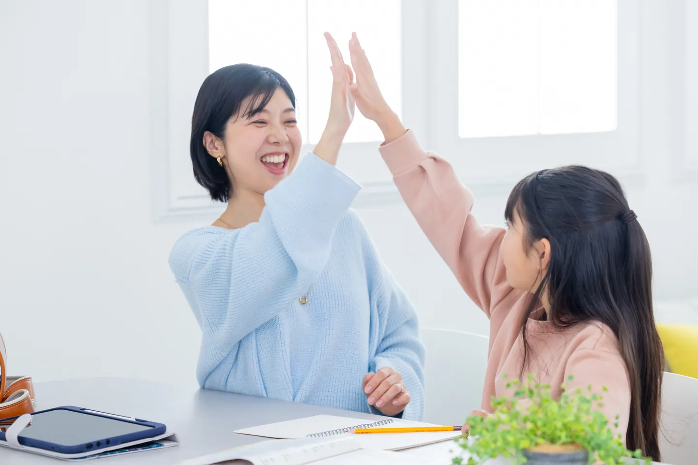 勉強を終えてハイタッチをする子どもと保護者